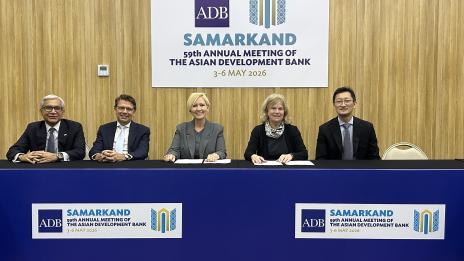 Five officials seated at a table beneath a sign for the Asian Development Bank’s 59th Annual Meeting in Samarkand, held 3–6 May 2026.