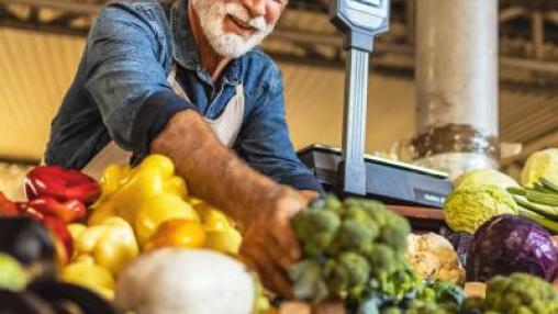Small business owner arranging vegetables